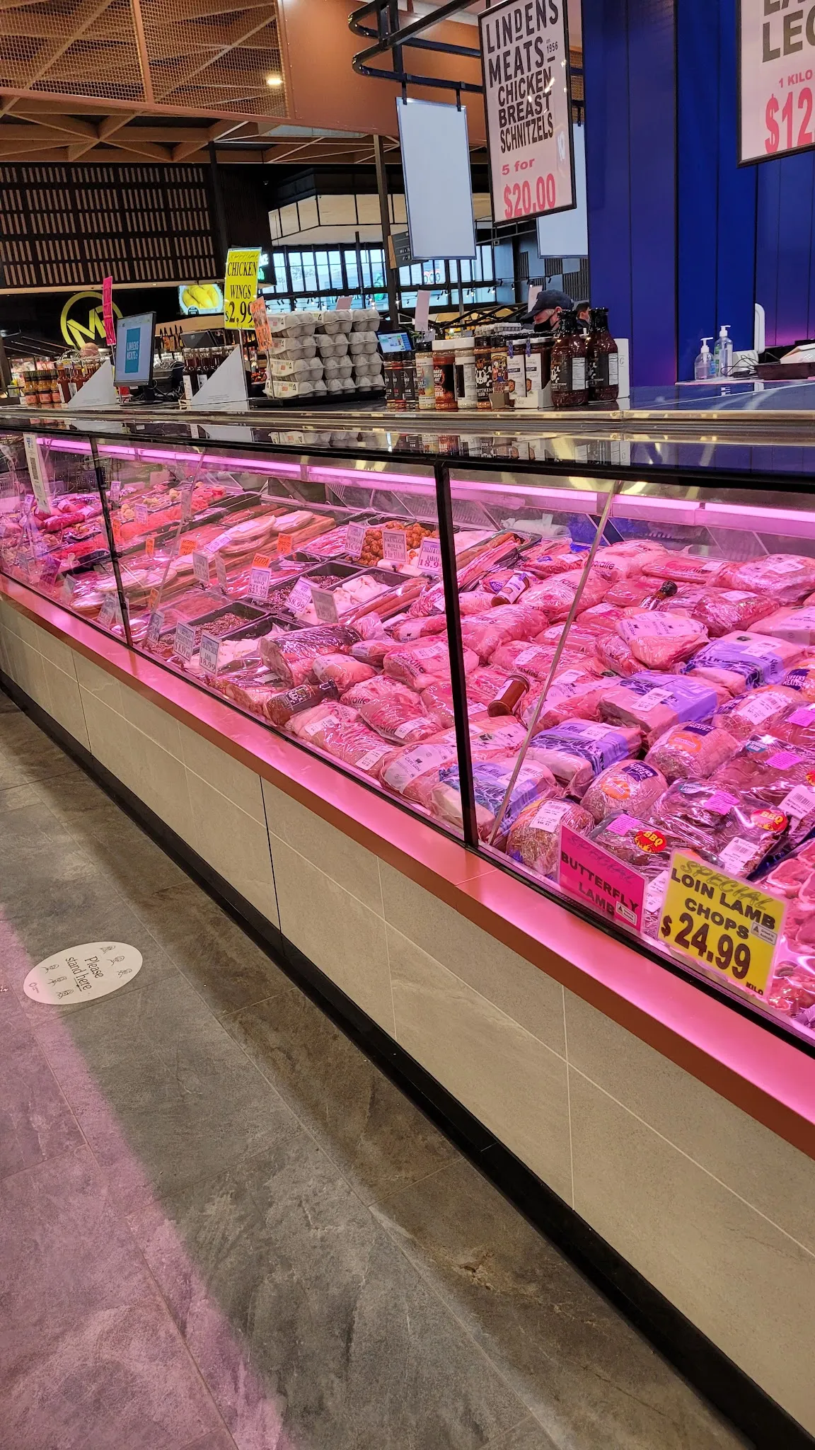 Lindens Meats refrigerated counter curving into the background, well-stocked with fresh cuts of meat, Loin Lamb Chops price sign visible
