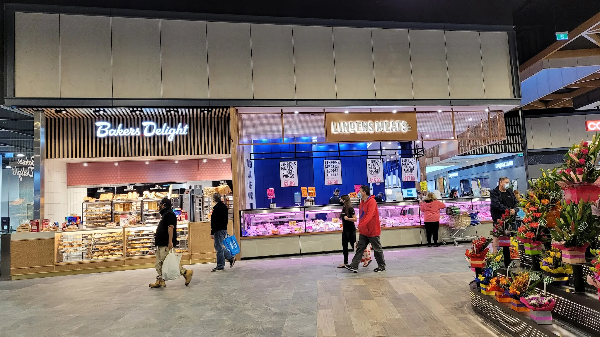 Lindens Meats at Karingal Hub alongside Bakers Delight and a florist, shoppers walking past the fresh food precinct